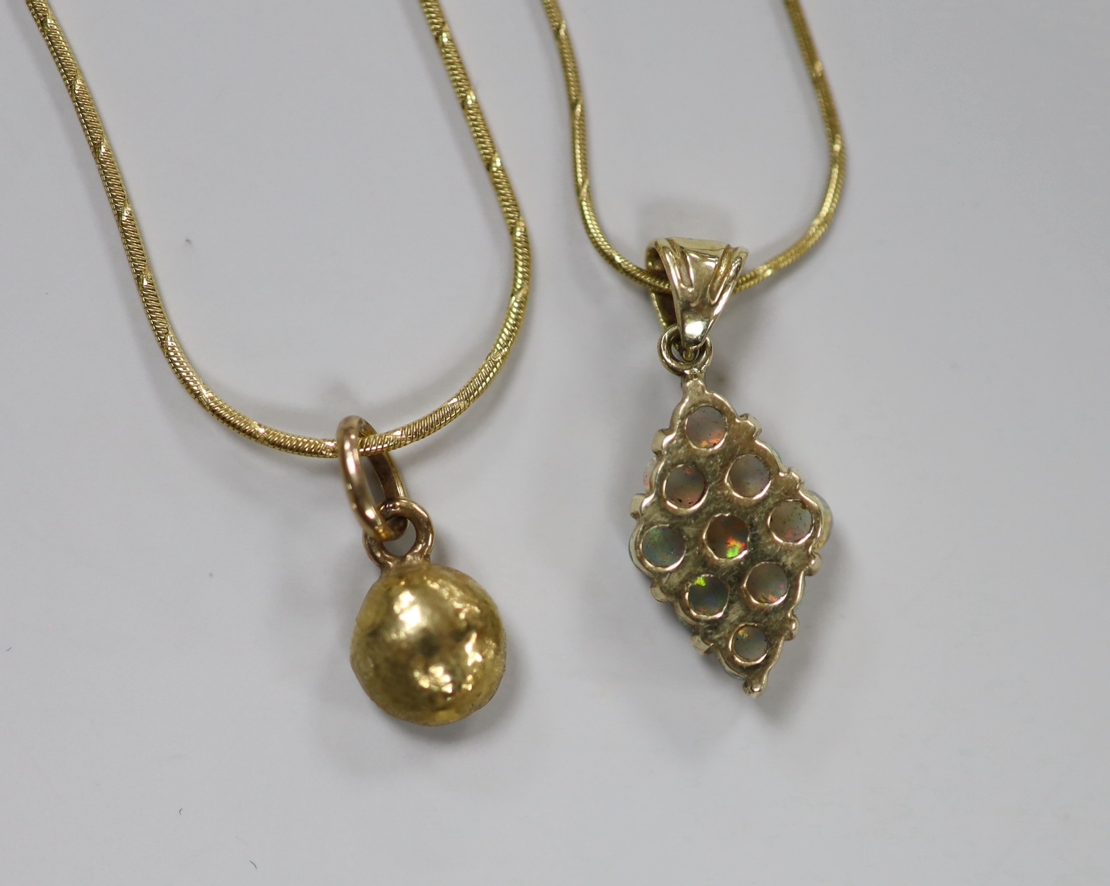 A modern 585 and white opal cluster set diamond shaped pendant, 17mm, on a 14k chain, 43cm and a yellow metal pendant on a 14kt chain, gross weight 11 grams.